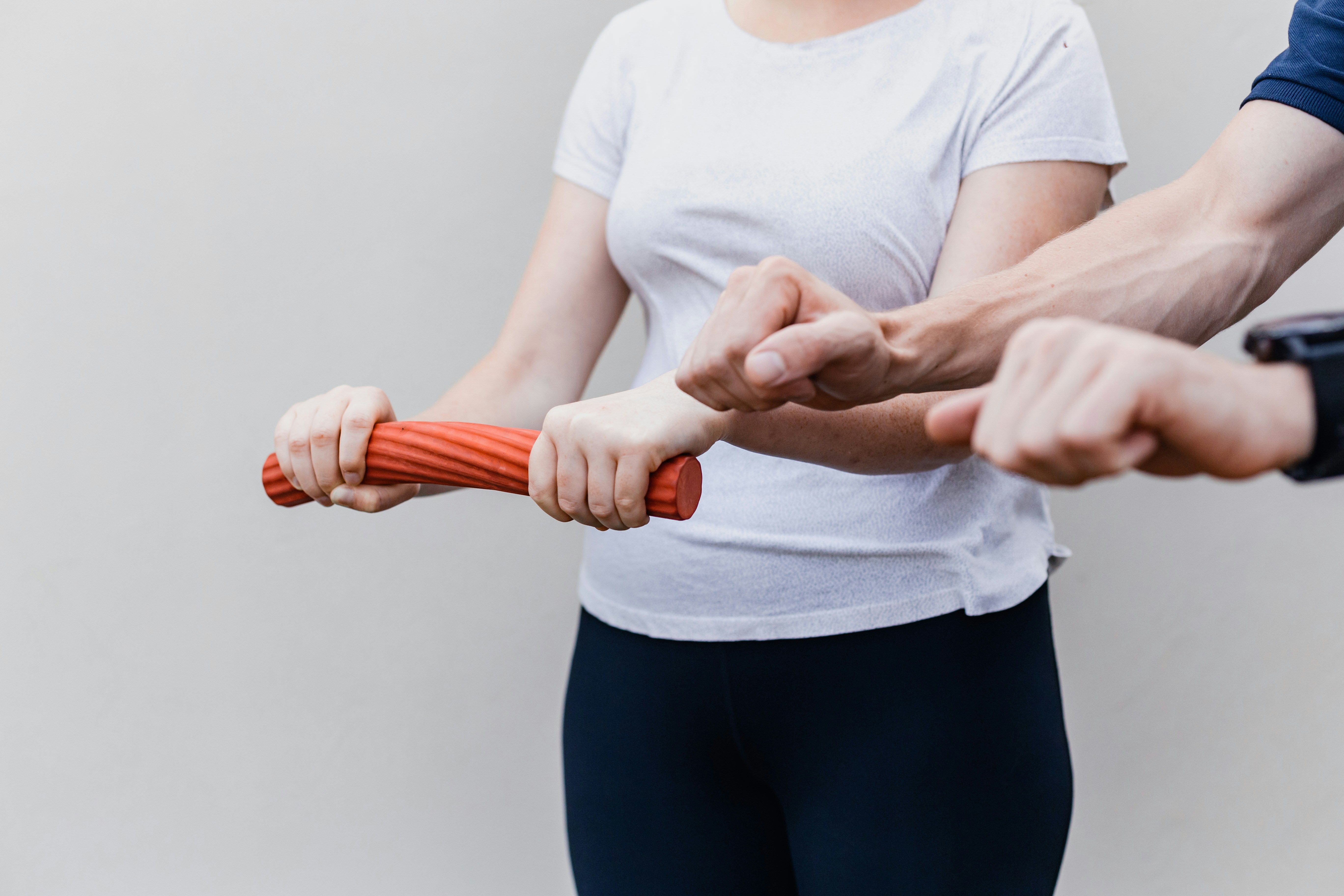 Person, beskuren ovanför axlarna, tränar på en vridrörelse med händerna, instruerad av en fysioterapeut.